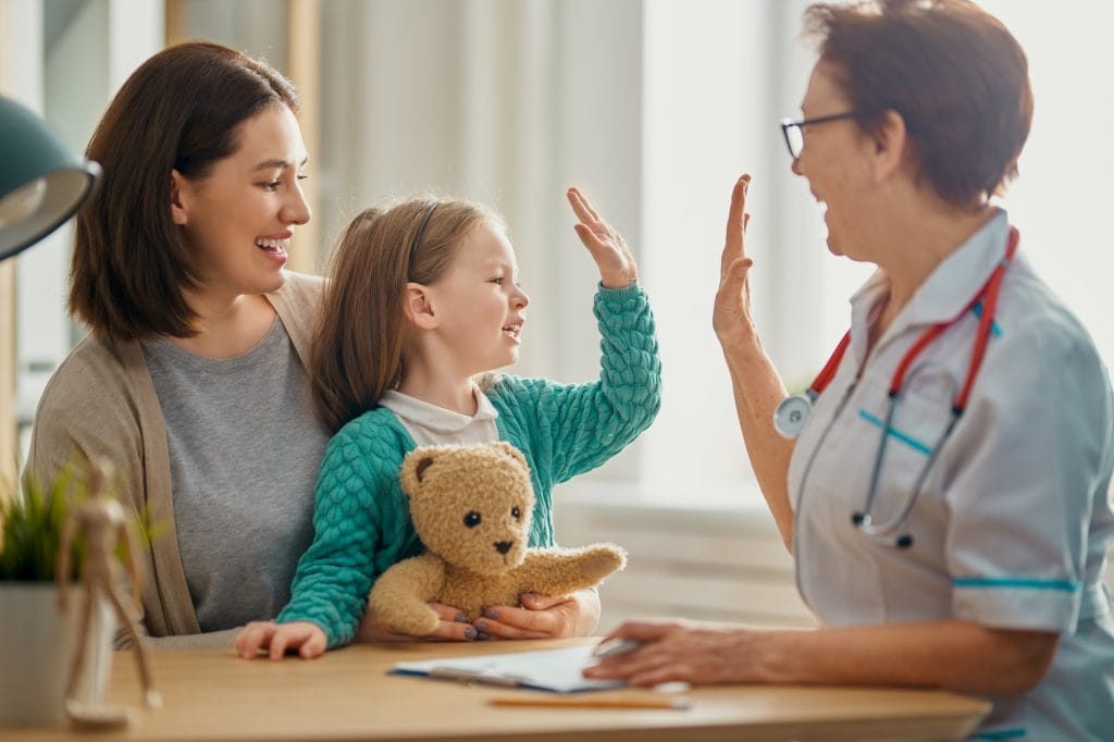 Child giving a doctor a high five during appointment. Pediatrics testimonial image.