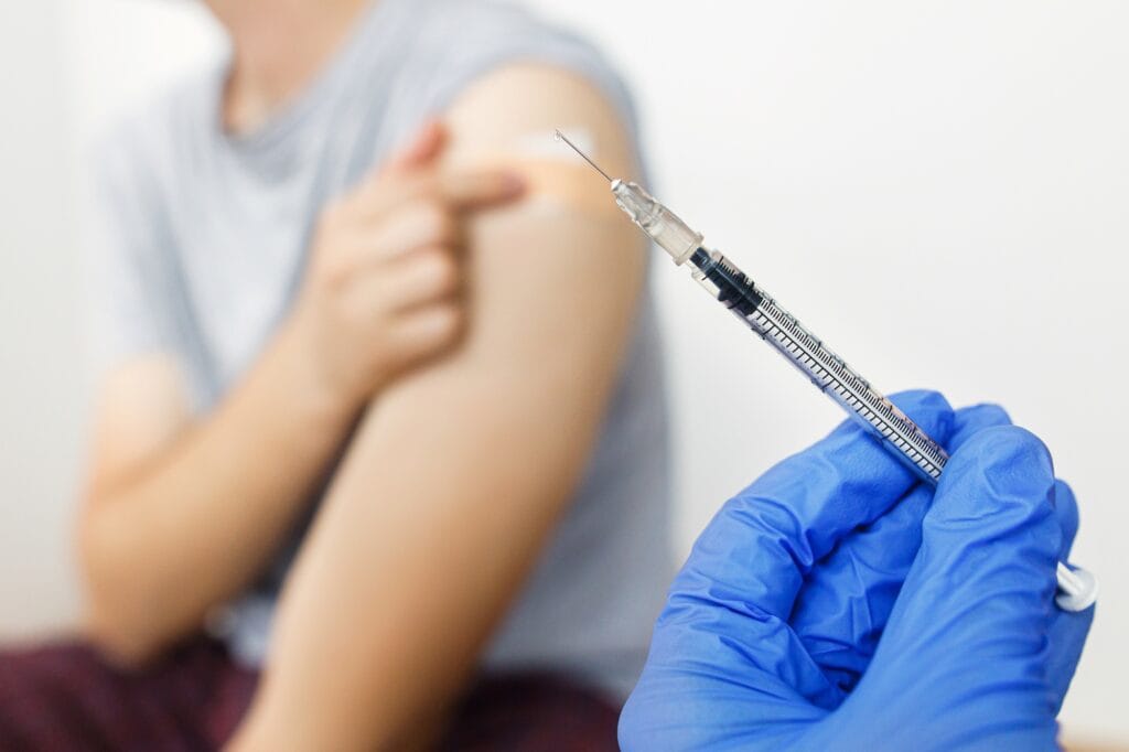 Vaccine syringe in doctor's hand, homeopathic healthcare background. Vaccination for health.