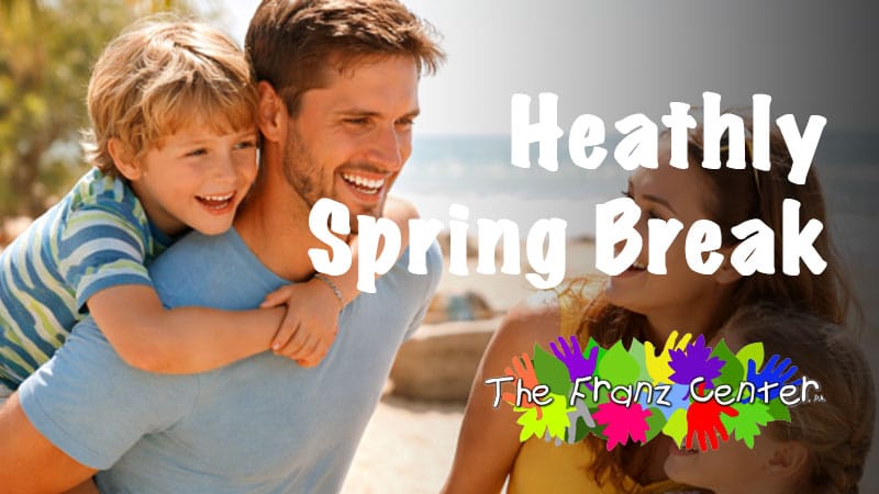 Happy family enjoying safe, healthy Spring Break fun. Father and son smiling on the beach, promoting wellness tips.