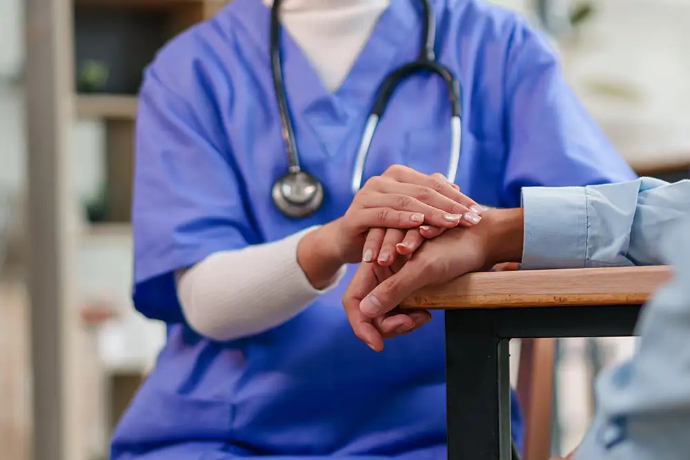 ADHD treatment: Doctor offering support, hand on patient's hand. Compassionate care for ADHD. Empathy in healthcare.