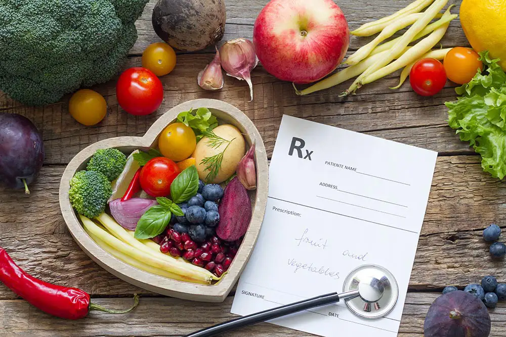 ADHD treatment: Heart-shaped bowl filled with colorful fruits and vegetables, alongside a prescription and stethoscope.