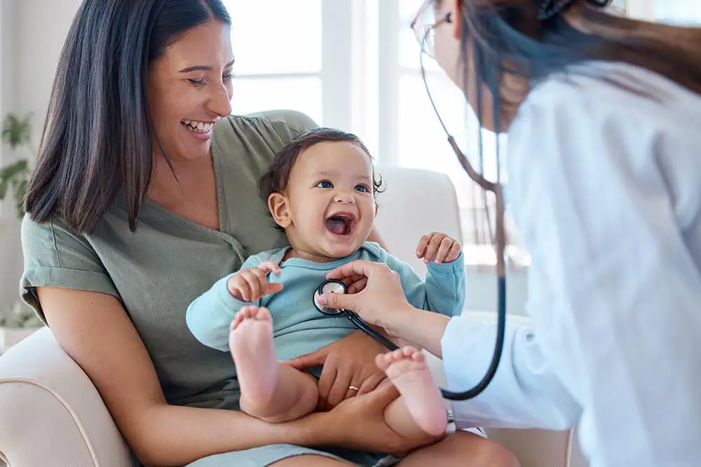 Smiling baby getting a checkup with stethoscope. Pediatric ADHD treatment assessment, early intervention concept.