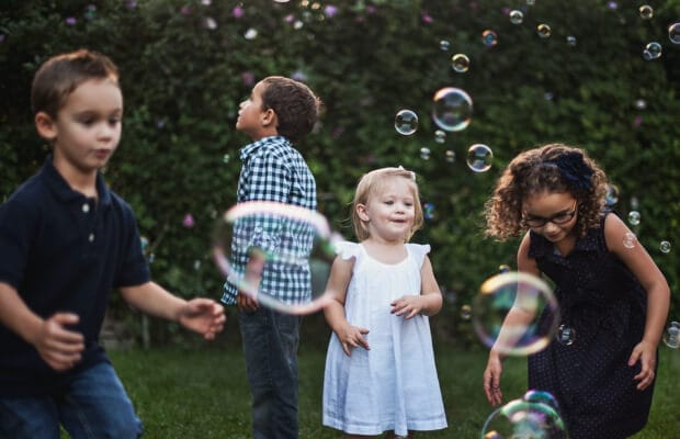 First Pediatrician: Children enjoy bubbles at a daycare home, playing in a safe outdoor environment.