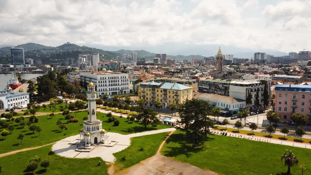 Virtual Visit Georgia: Aerial view of Batumi's clock tower, city skyline, and Black Sea port. Travel to Georgia online.