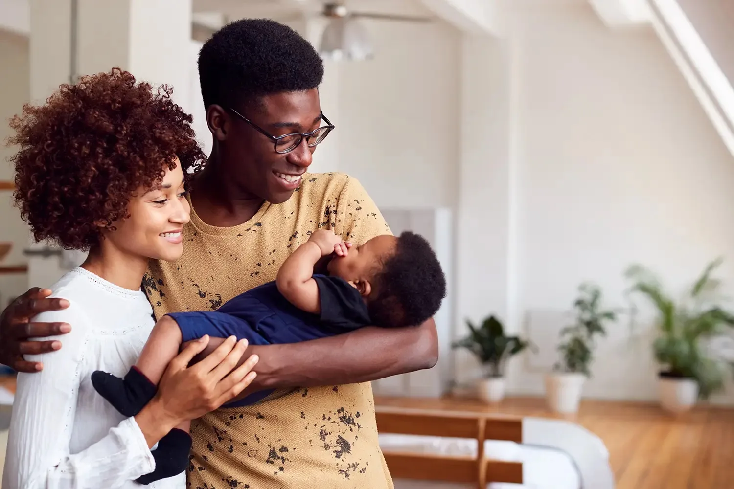 Loving parents holding newborn baby at home. Parent resources concept. Happy family, parenthood.