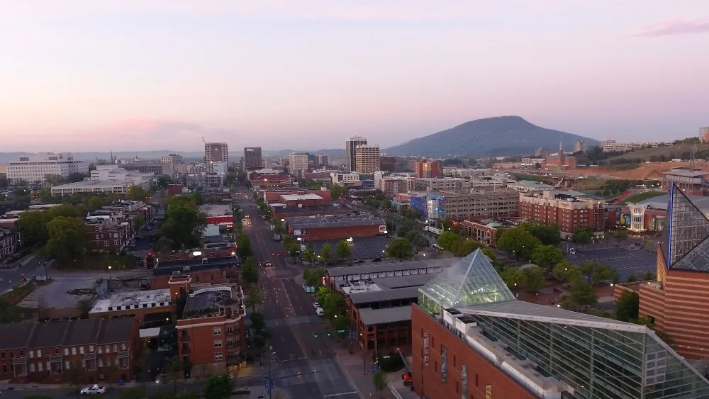 Virtual Visits Tennessee: Cityscape view with buildings, trees, and mountain in the background. Captured in tennessee.jpg.