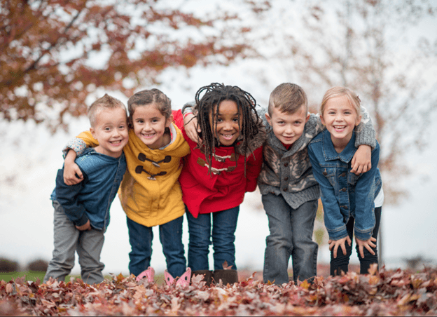 Happy diverse kids in nature, fall leaves. Outdoor ADHD treatment benefits, nature therapy, reduced symptoms.